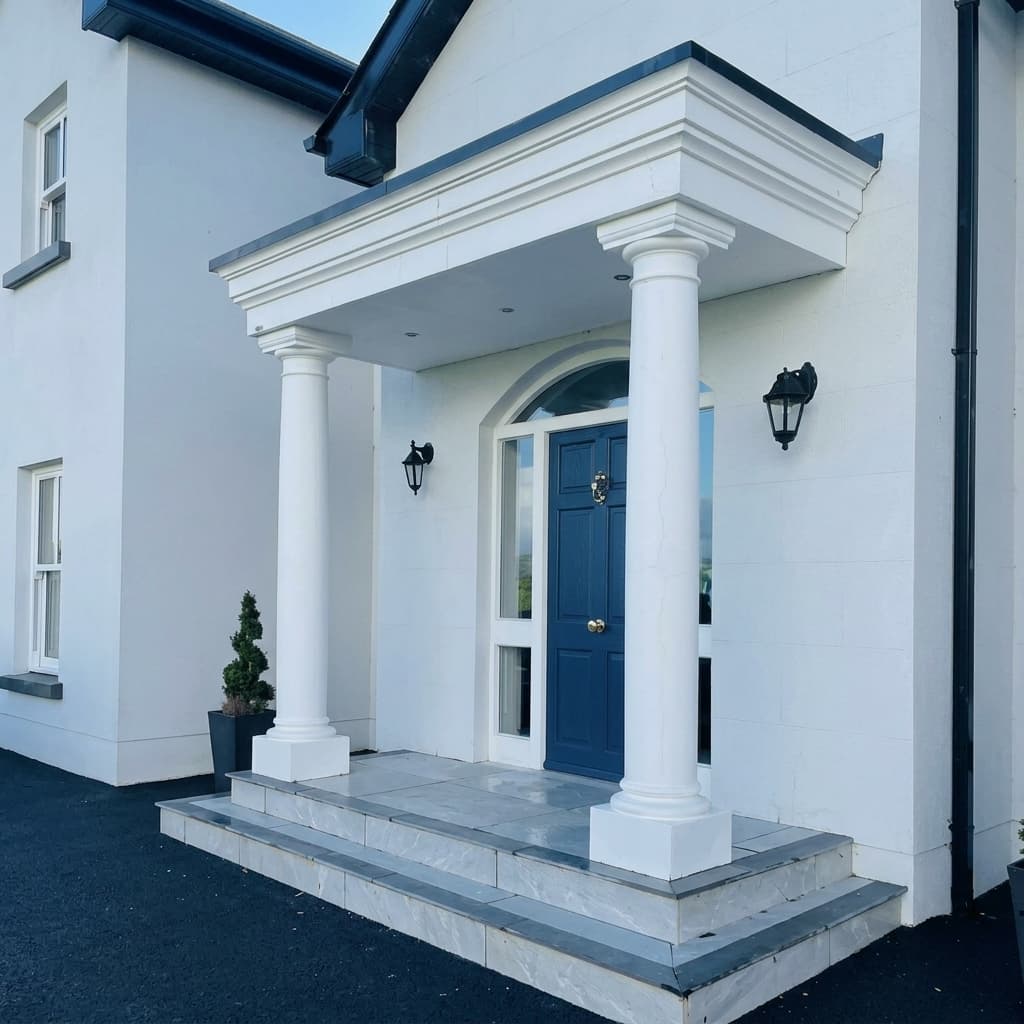 Grand portico canopy with classical white columns and blue door on detached home