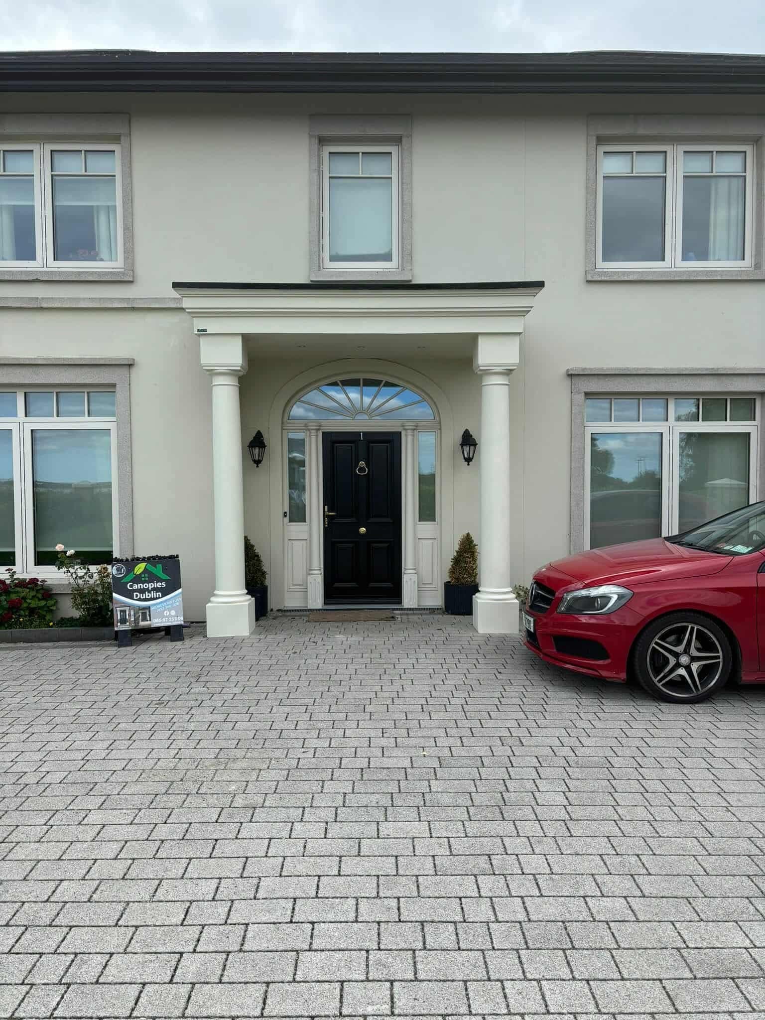 Large portico canopy with round columns and arched doorway on detached residence