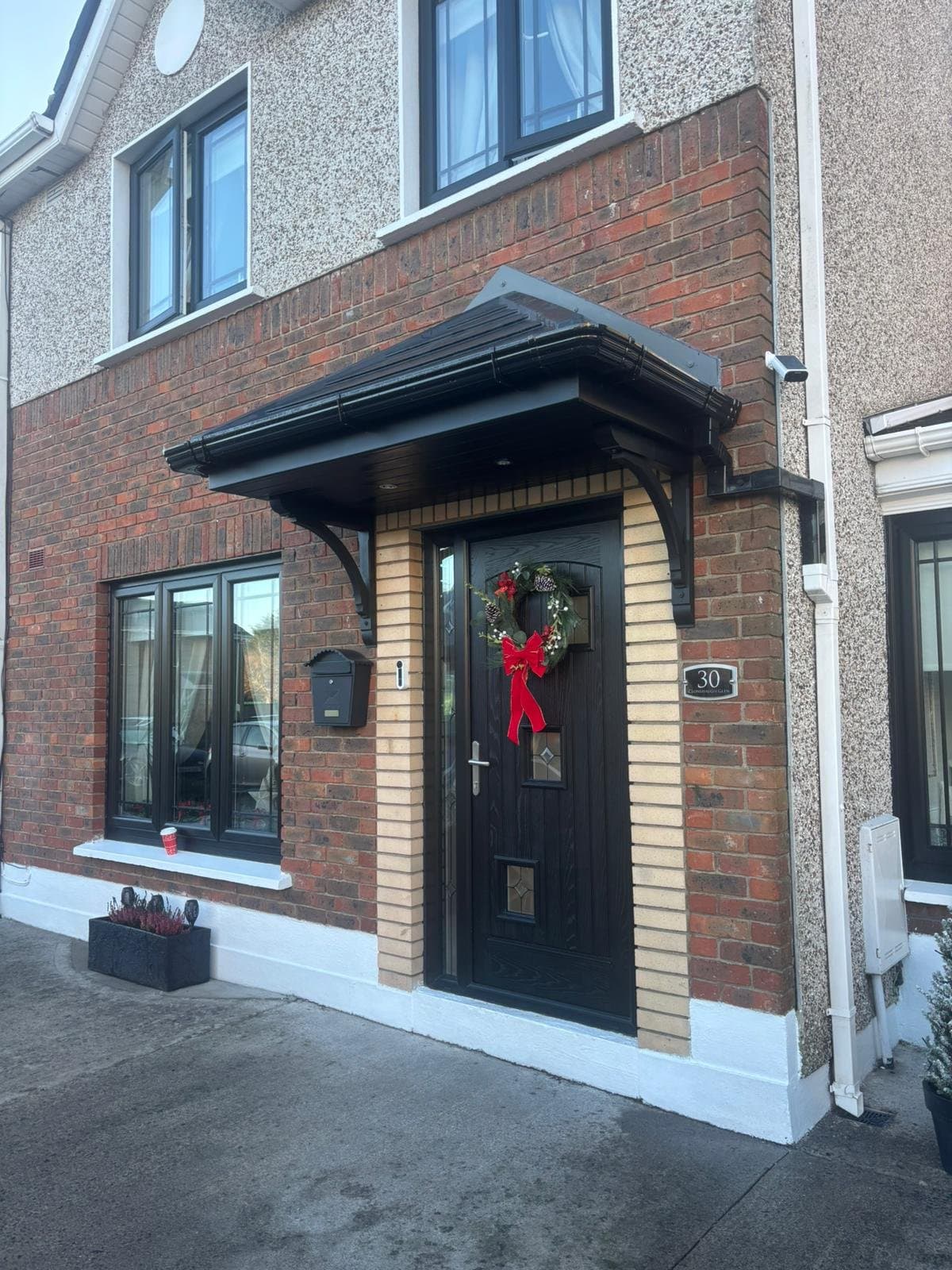 Hipped canopy on red brick house with Christmas wreath