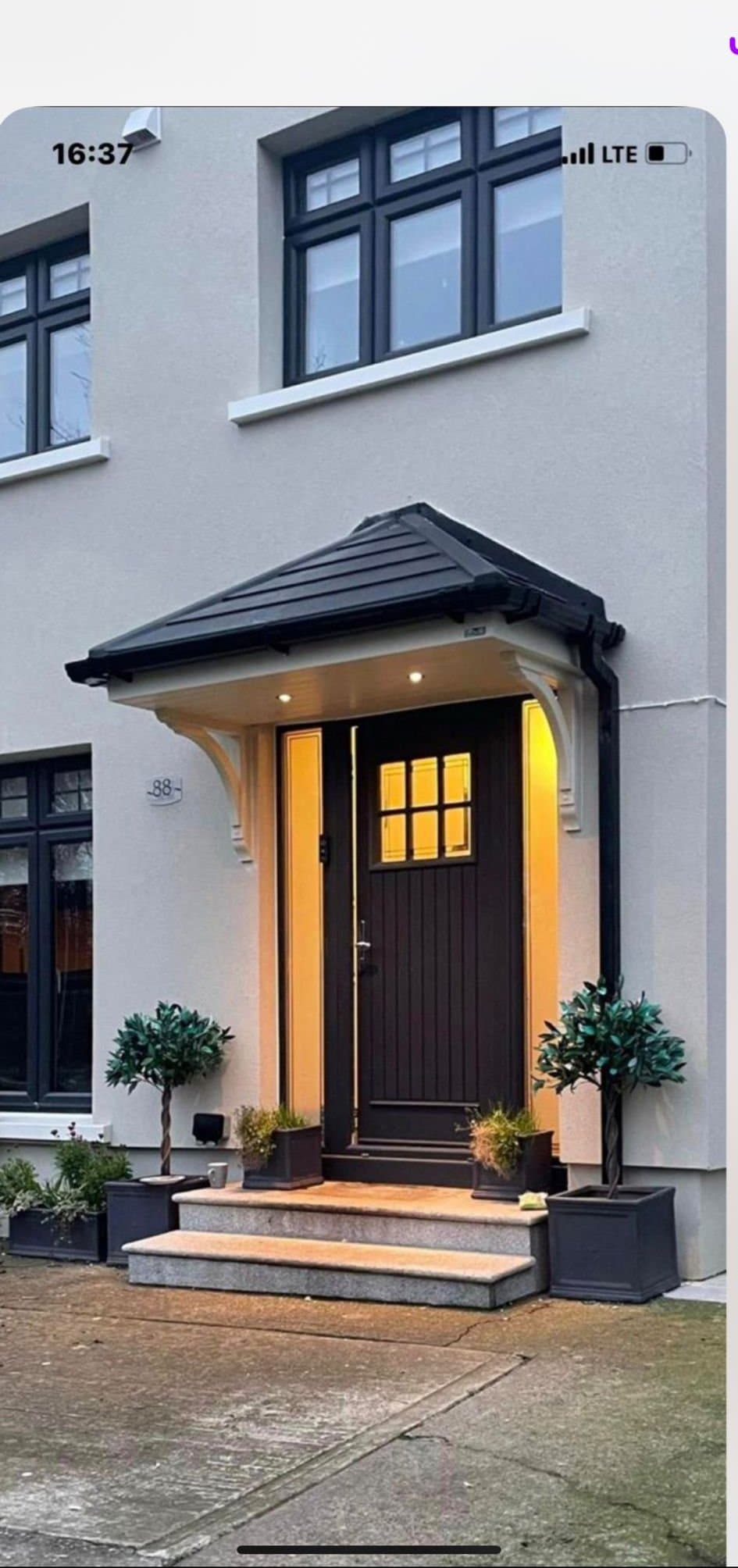 Portico canopy with warm ambient lighting over front door in evening